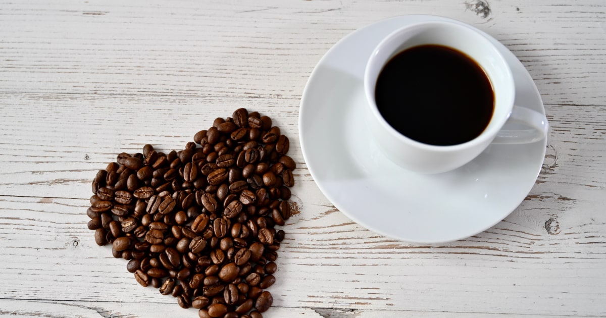 coeur en grain de café à côté d'un café dans une tasse